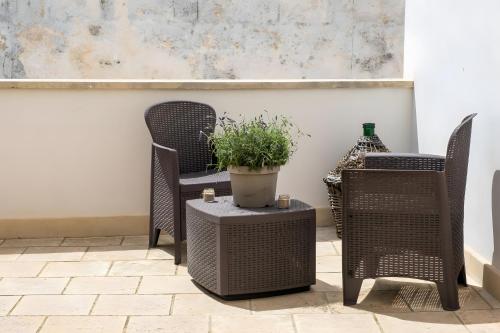 a patio with two chairs and a potted plant at Le due Torri in Avetrana