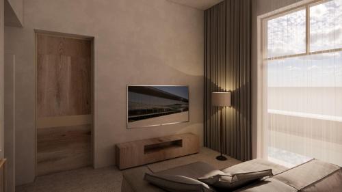 a living room with a television on a wall at La Gaia - Adult Only in Alanya