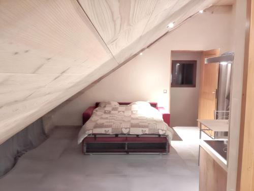 une chambre avec un lit dans un grenier dans l'établissement Studio cosy à Saint-Jean-d'Arves 29 m² Vue montagne, à Saint-Jean-dʼArves