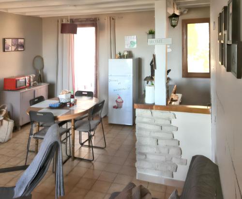 une cuisine et une salle à manger avec une table et un réfrigérateur dans l'établissement Maison charmante à Vachères avec vue sur la montagne, à Vachères