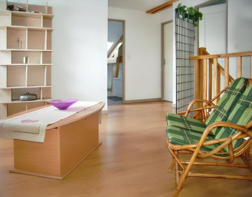 a living room with a table and a chair at Maison spacieuse près de Gérardmer avec vue sur le lac in Gérardmer