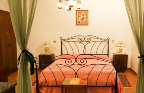 フィリーネ・ヴァルダルノにあるPodere Il Fattoioのベッドルーム1室(赤いベッド1台、ナイトスタンド2台付)