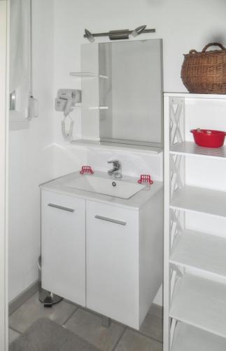 une salle de bain blanche avec un lavabo et un miroir dans l'établissement Maison spacieuse près de Gérardmer avec vue sur le lac, à Gérardmer