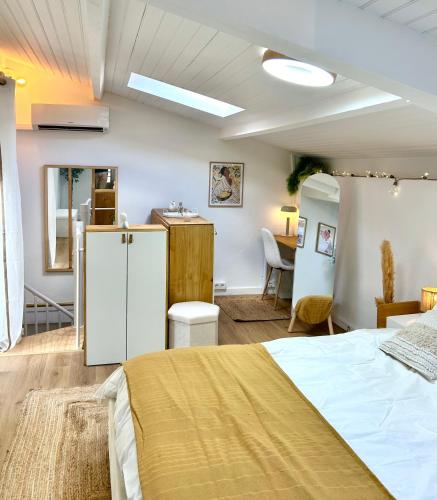 Cet appartement comprend une chambre avec un lit, une cuisine et une table. dans l'établissement L 'Écrin - Balnéo & Cinéroom, à Poitiers