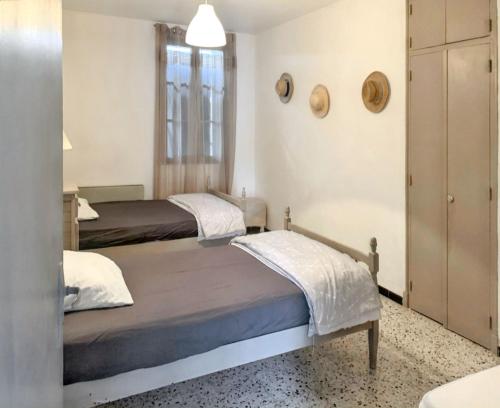 a bedroom with two beds and a closet at Maison accueillante à Orgnac-l'Aven avec piscine partagée in Orgnac-lʼAven