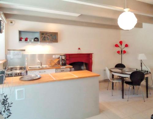 a kitchen and dining room with a table and a fireplace at Charmante maison avec cheminée à Saint-Jacut-de-la-Mer in Saint-Jacut-de-la-Mer