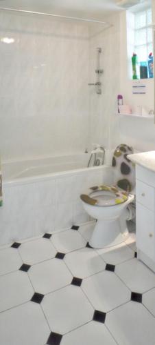 une salle de bain blanche avec toilettes et baignoire dans l'établissement Villa charmante à Meynes avec piscine privée, à Meynes