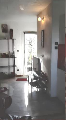 a living room with a tv sitting on a coffee table at Appartement charmant à Villeneuve avec jardin in Villeneuve-dʼAveyron