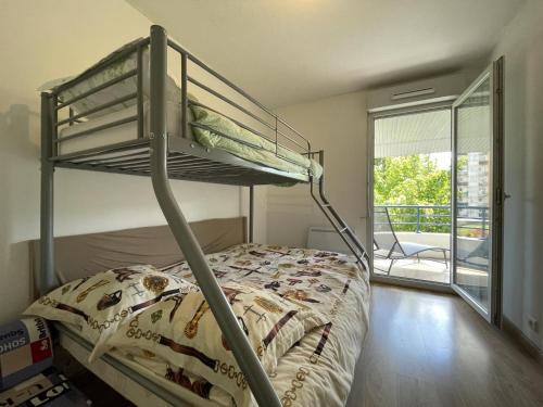 Un dormitorio con una litera y un balcón. en Duplex villa 2, en Pau