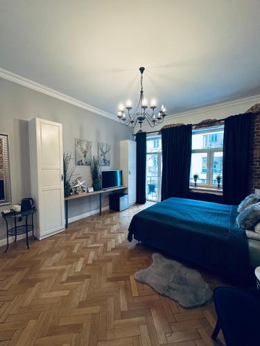 a bedroom with a green bed and a chandelier at Apartamenty Narutowicza 52 parking free in Lublin