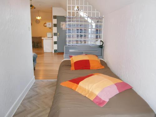 - un lit dans une chambre avec 2 oreillers colorés dans l'établissement Appartement moderne à Lourdes avec jacuzzi, 54 m², à Lourdes