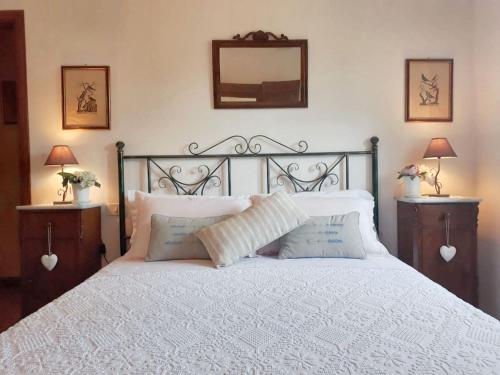 a bedroom with a large white bed with two night stands at Spacious Apartment in Lisciano Niccone with Mountain View in Mercatale