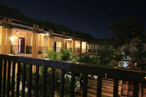 a building with a fence in front of it at night at Surya Guest House in Kanigaran