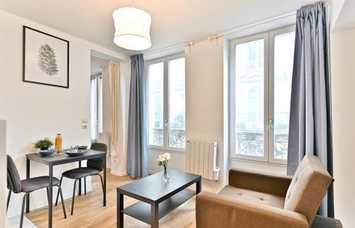 un salon avec un canapé et une table dans l'établissement Apartment near Mairie Paris 10ème - III, à Paris