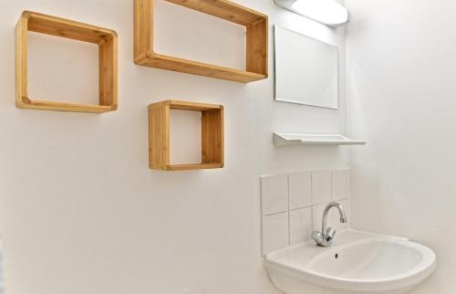 une salle de bain avec un lavabo et des miroirs au mur dans l'établissement Apartment near Mairie Paris 10ème - III, à Paris