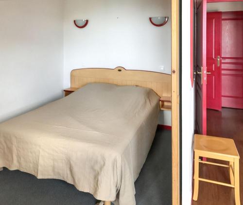 - une chambre avec un lit et une porte rouge dans l'établissement Appartement cosy à Saint François Longchamp 35 m², à Saint-François-Longchamp