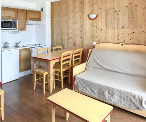 Cette chambre comprend un lit, une table et une cuisine. dans l'établissement Appartement cosy à Saint François Longchamp 35 m², à Saint-François-Longchamp