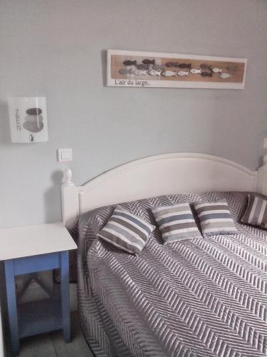 - une chambre avec un lit avec des oreillers et un bureau dans l'établissement Charmante maison à Guilvinec avec piscine partagée, au Guilvinec