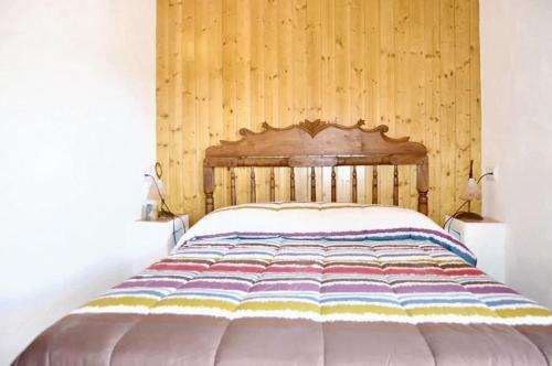 a bed in a room with a wooden wall at Charming house with mountain view in Siles + Garden in Siles