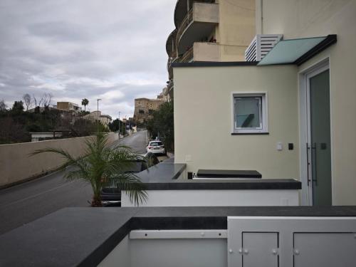 a white building with a window and a street at Shanti Rooms & Apartments Castello in Bacoli