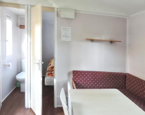 a small room with a couch and a toilet at Bungalow charmant à Rochechouart avec vue sur lac in Rochechouart