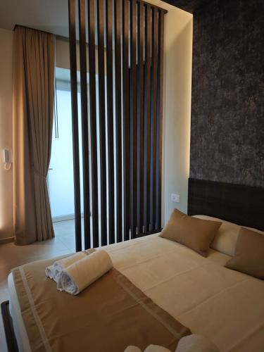 a bedroom with a large bed and a large window at Shanti Rooms & Apartments Castello in Bacoli