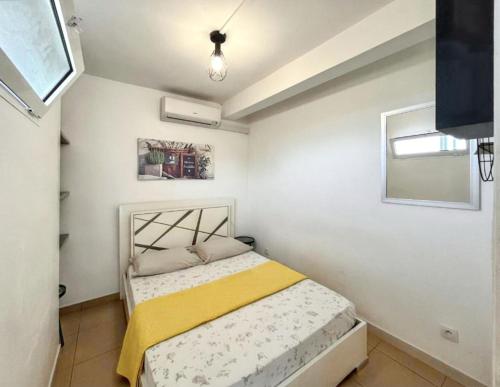 a bedroom with a bed with a yellow blanket at Villa enchanteresse à Saint-Benoît avec piscine privée in Saint-Benoît