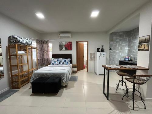 a bedroom with a bed and a desk and a refrigerator at Casa Copacabana 2 in Urubici