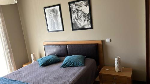 a bedroom with a bed with two blue pillows at Pórtico de Malpique in Albufeira