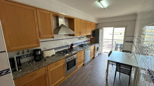 a kitchen with wooden cabinets and a counter top at Pórtico de Malpique in Albufeira