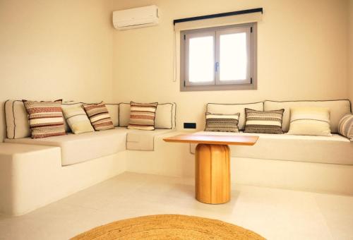 a room with a couch with pillows and a table at Agave Donousa Suites in Donoussa