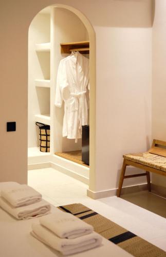 a room with a closet with a white shirt in it at Agave Donousa Suites in Donoussa