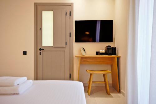 a bedroom with a bed and a table with a stool at Agave Donousa Suites in Donoussa