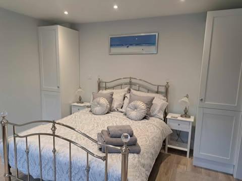 a bedroom with a bed with pillows on it at Bow Cottage in Bridport