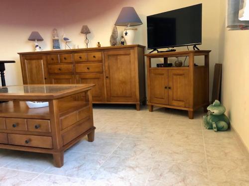 a living room with wooden furniture and a flat screen tv at Casa Terraço in São Bernardino