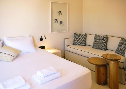 a small room with two beds and a couch at Agave Donousa Suites in Donoussa