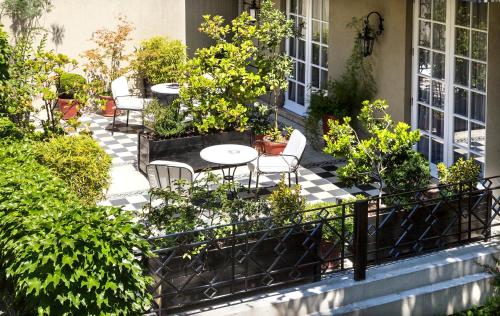 a patio with tables and chairs and plants at Hotel Boutique Le Reve in Santiago