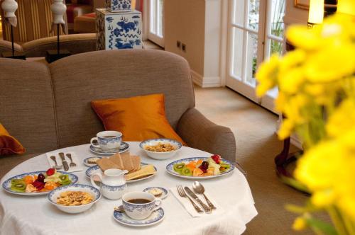 a table with plates of food and cups of coffee at Hotel Boutique Le Reve in Santiago