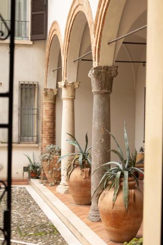 a row of pillars with potted plants in a building at Casa Petrucci centro storico in Forlì