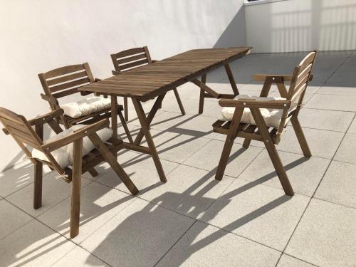 una mesa de madera y dos sillas y una mesa de madera y sillas en Magellan, en Colombes