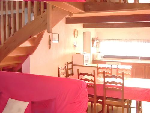 a dining room with a red table and chairs at Maison chaleureuse près des pistes de Barcelonnette - Cheminée in Barcelonnette