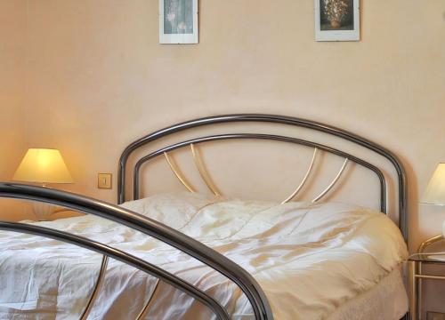 a bed in a room with two lamps at Appartement confortable à Oderen 68 m² avec piscine partagée in Oderen