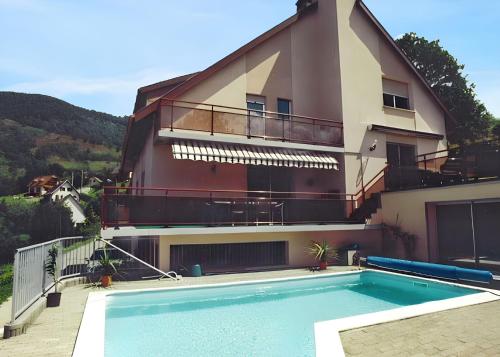 un immeuble avec une piscine devant un immeuble dans l'établissement Appartement confortable à Oderen 68 m² avec piscine partagée, à Oderen