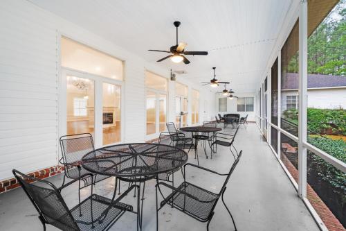 a patio with tables and chairs and a ceiling fan at Tranquil 1 BR Studio in Grand Bay - Oak & Fountain in Grand Bay