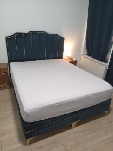 a bed with a black frame and white mattress at Lux chamber in Brussels