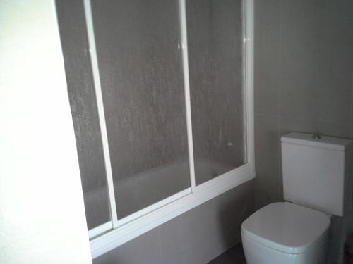 a bathroom with a toilet and a window at Ático centro ,parking edificio INCLUIDO in Huelva