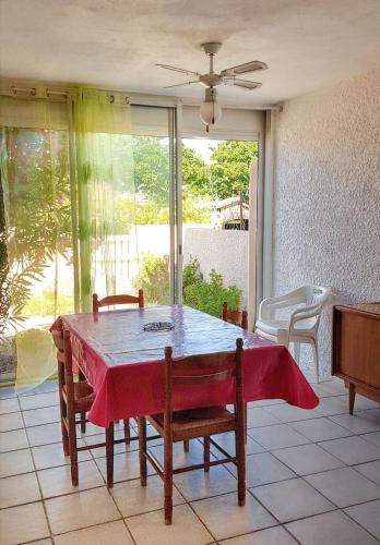 une table de salle à manger avec une nappe rouge dessus dans l'établissement Appartement cosy à Port Leucate 44 m² avec terrasse et jardin, à Port-Leucate