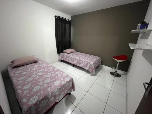 a small room with two beds and a stool at Apartamento muito aconchegante in Paulista