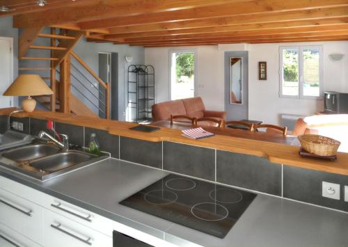 une cuisine avec un évier et un salon dans l'établissement Maison charmante à Sauzon avec jardin et terrasse, à Sauzon