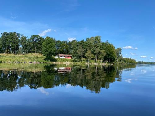 a house on an island in the middle of a lake at Joarsbo, Stuga 1, Sjölyckan in Kalv